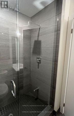 Toronto (Don Valley Village) condo for rent - A bathroom with a glass shower stall and a toilet.
