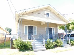 New Orleans apartment for rent - A house with a grey siding and a white door.