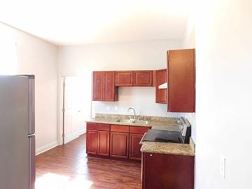 New Orleans apartment for rent - A kitchen with wooden cabinets and a granite countertop.