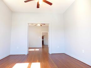 New Orleans apartment for rent - A room with a ceiling fan and a doorway leading to another room.