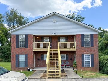 Louisville apartment for rent - A two-story brick house with a wooden staircase leading to the second floor.