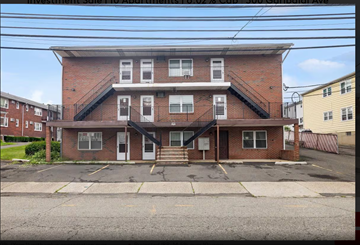 Lodi apartment for rent - A red brick building with a parking lot in front.