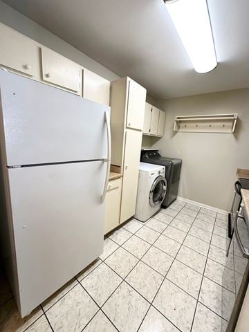 Lafayette house for rent - A white refrigerator is in a kitchen with white cabinets and a white washer and dryer.