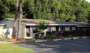 Pensacola apartment for rent - A building with a parking lot in front of it.