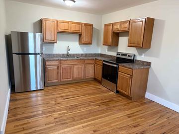 Syracuse apartment for rent - A kitchen with wooden cabinets and a stainless steel refrigerator.