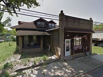 West Elizabeth apartment for rent - A house with a brown roof and a porch with a white door.