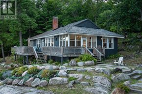 Muskoka Lakes (Medora) house for rent - A house with a porch and a rocky front yard.