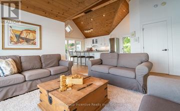 Muskoka Lakes (Medora) house for rent - A living room with a wooden coffee table and grey couches.