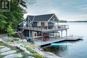 Muskoka Lakes (Medora) house for rent - A house with a deck and a dock on a lake.