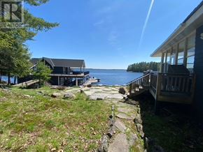 Muskoka Lakes (Medora) house for rent - A house with a deck overlooking a body of water.