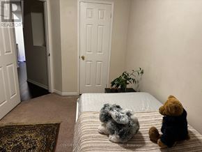 Mississauga (Meadowvale Village) townhouse for rent - Teddy bears sitting on a bed in a room with a door and a plant.