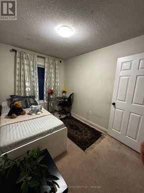 Mississauga (Meadowvale Village) townhouse for rent - A bedroom with a bed, a chair, and a door.