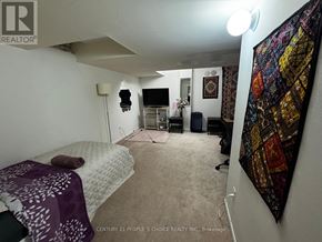 Mississauga (Meadowvale Village) townhouse for rent - A bedroom with a bed, a chair, and a wall hanging.