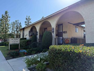 Anaheim apartment for rent - The front of a building called The Arches with a sign in front of it.