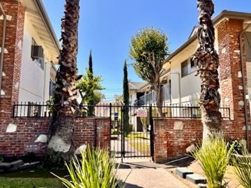 Anaheim apartment for rent - A house with a black gate and a palm tree in front.