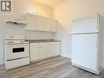 Windsor apartment for rent - A white fridge stands in a kitchen with white appliances and cabinets.