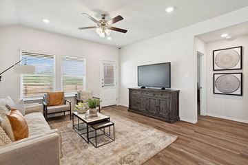 San Antonio apartment for rent - A living room with a couch, a coffee table, a television, and a ceiling fan.