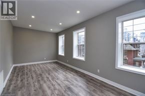 Hamilton house for rent - A room with wooden flooring and two windows.