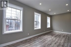 Hamilton house for rent - A room with grey walls and wooden flooring with two windows.
