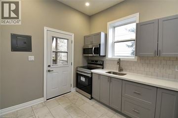 Hamilton house for rent - A kitchen with a white sink and grey cabinets.