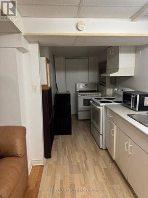 Brampton (Fletcher's Creek Village) house for rent - A kitchen with white cabinets and a wooden floor.