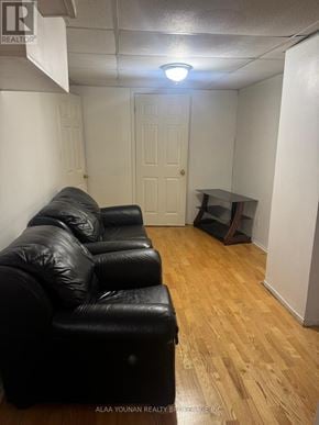 Brampton (Fletcher's Creek Village) house for rent - A black leather couch in a room with wooden flooring and a white door.