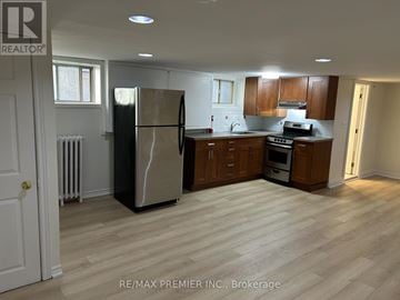 Toronto (Broadview North) multi-family for rent - A kitchen with a refrigerator, oven, and microwave.