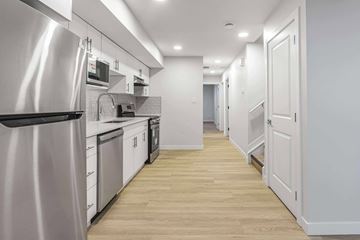 Edmonton apartment for rent - A modern kitchen with a stainless steel refrigerator and wooden flooring.