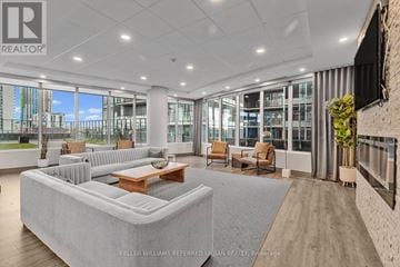 Hamilton (Central) condo for rent - A spacious living room with a large grey sofa and a wooden coffee table.