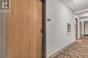 Hamilton (Central) condo for rent - A hallway with a wooden door and a carpeted floor.