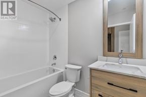 Hamilton (Central) condo for rent - A white toilet sits next to a white sink in a bathroom.