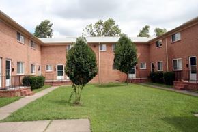 Newport News apartment for rent - a brick building with a lawn and trees in front of it