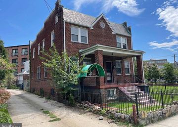 Washington apartment for rent - A red brick house with a green arched entrance gate.