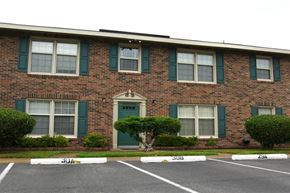 Newport News apartment for rent - the front of a brick building with green doors and windows