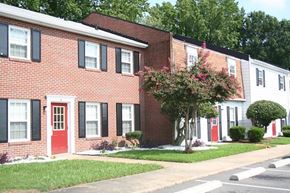 Hampton apartment for rent - a brick building with a red door and a tree in front of it