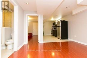 Mississauga (Churchill Meadows) house for rent - A spacious room with a wooden floor and a black refrigerator.