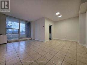 Toronto (Newtonbrook West) condo for rent - A spacious room with tiled flooring and a sliding glass door leading to a balcony.