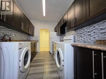 Toronto (Newtonbrook West) condo for rent - A kitchen with brown cabinets and a stone backsplash.