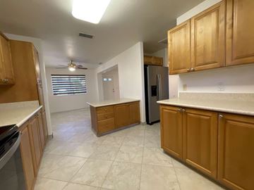 Waipahu apartment for rent - A kitchen with wooden cabinets and a refrigerator.