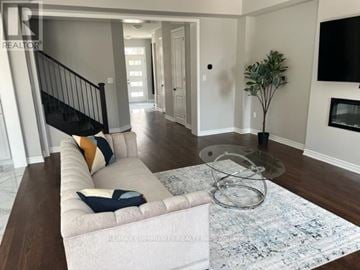 Pickering house for rent - A living room with a white couch and a glass coffee table.