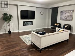 Pickering house for rent - A living room with a couch, television, and a plant.