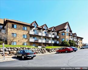 Madison apartment for rent - a large apartment building with cars parked in a parking lot