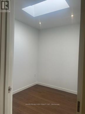 Toronto (Moss Park) condo for rent - A room with a skylight and wooden flooring.