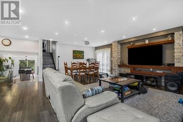 Toronto (Morningside) house for rent - A living room with a grey sofa and a wooden entertainment center.