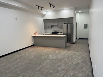 Muskegon apartment for rent - A kitchen with a refrigerator, stove, and cabinets.