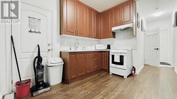 Toronto (Moss Park) townhouse for rent - A kitchen with wooden cabinets and white appliances.