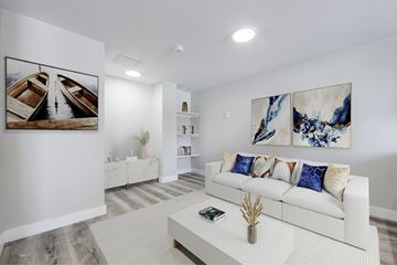 Kitchener apartment for rent - A living room with a white couch and a painting on the wall.