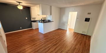 Long Beach apartment for rent - A kitchen with white cabinets and a black countertop.