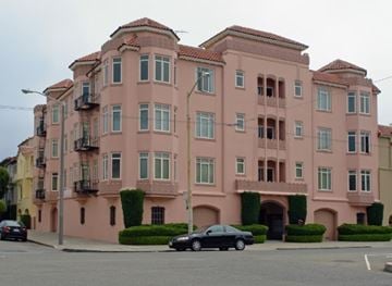 San Francisco apartment for rent - A pink building with a car parked in front.