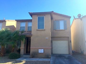 Las Vegas house for rent - a house with a garage door and a palm tree